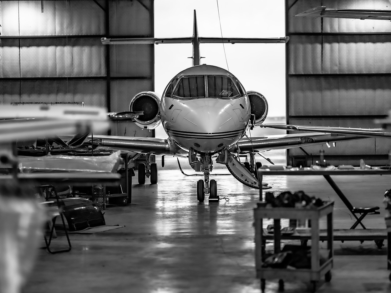 Aircraft in the Plane Place Aviation hangar — black and white