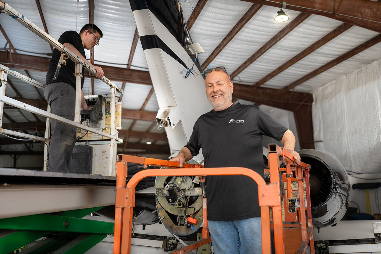 Technician on lift performing aircraft maintenance